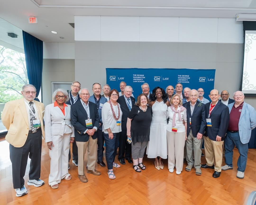 GW Law alumni pose for a photo with dean matthew